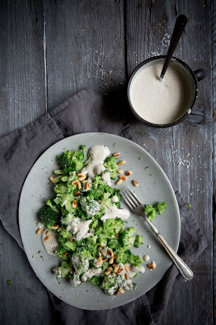 Brokkoli-Salat auf Platte mit Ceasar Dressing auf dunklem Tisch