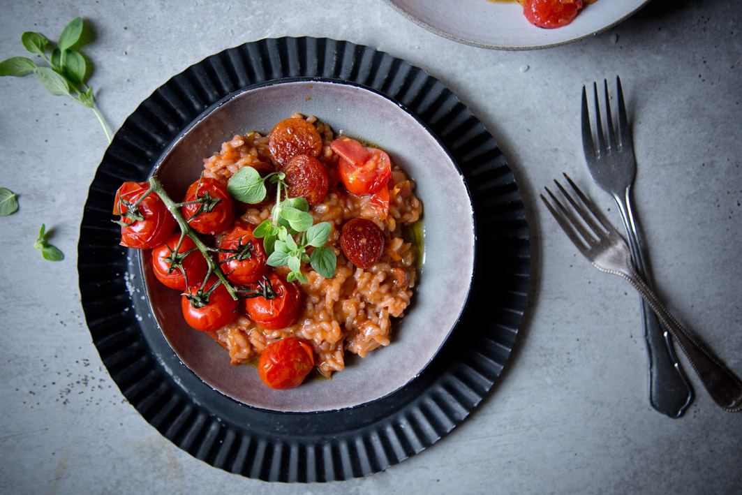 Tomatenrisotto mit Chorizo und Rispe Tomaten auf Teller