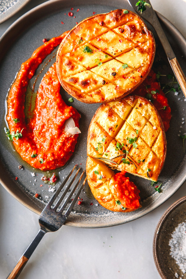 Zwei Ofenkartoffeln mit Tomatensauce auf Teller und Besteck