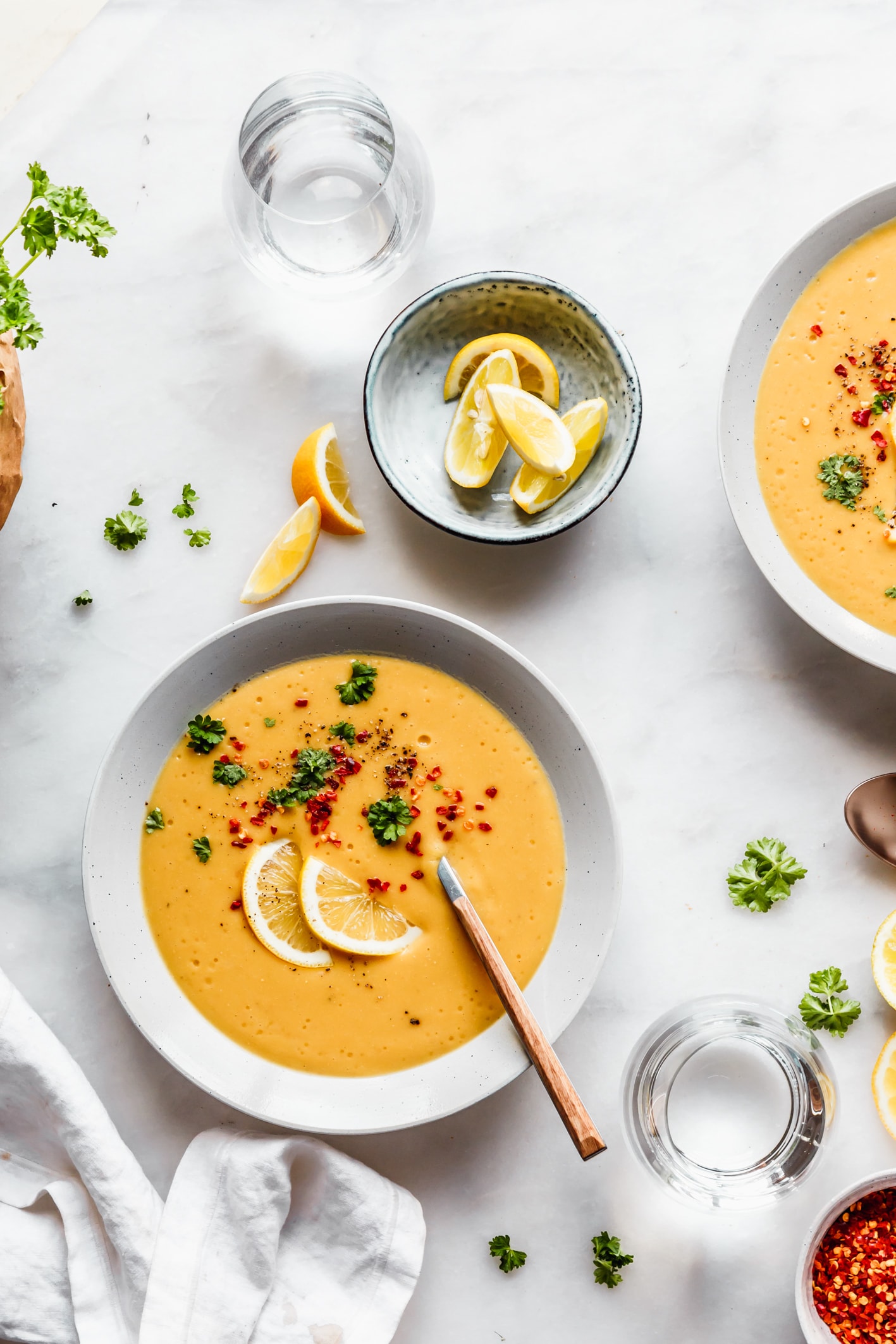 Linsensuppe aus Vorrats-Linsen Zwei Teller mit türkischer Linsensuppe garniert mit Zitrone und Petersilie